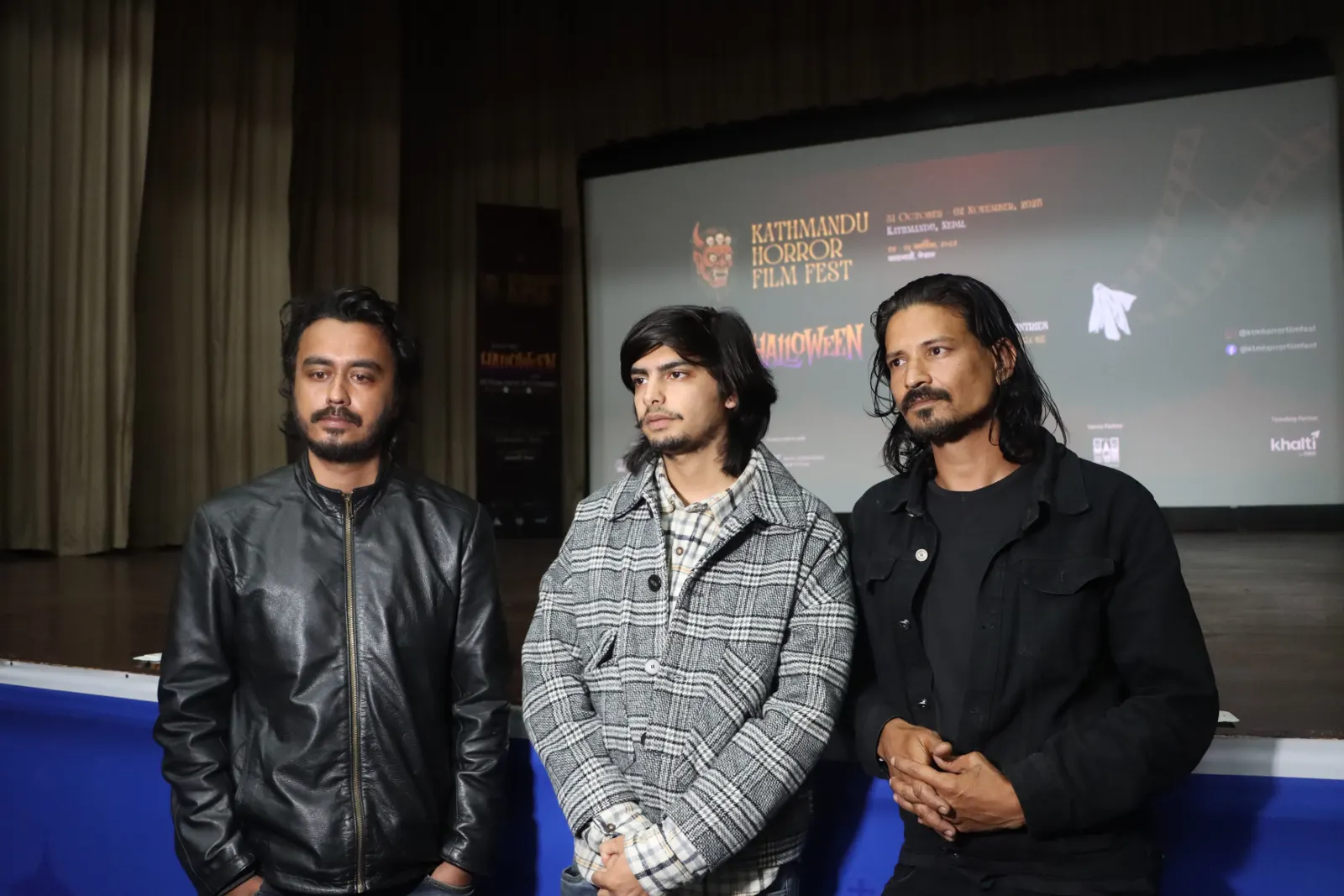 Three filmmakers on stage in front of the KHFF 2025 backdrop